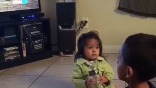 Kid in green shirt throws water bottle at kid in black shirts face