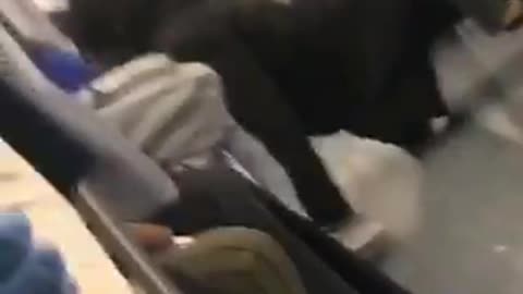 Person with black coat push ups on train floor