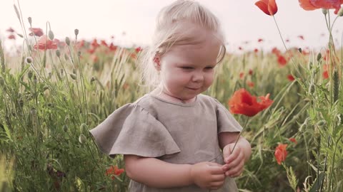 Girl Smelling Red Poppy Flower