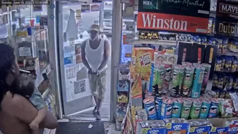 Detroit gas station video shows armed suspect drawing gun on man holding baby on shoulder.