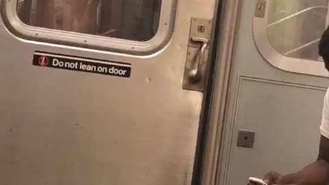 Shirtless guy standing between two subway carts