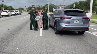 Woman in Florida climbs on top of a car in traffic