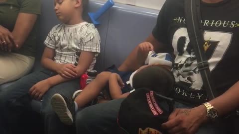 Man and boys fall asleep on train