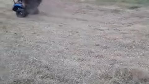 Guy in blue atv four wheeler flips forward rolls grass jump