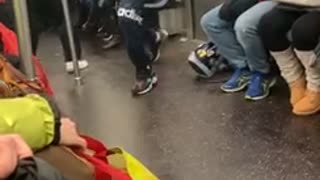 Subway performer swings on hand rail poles, flips hat onto head