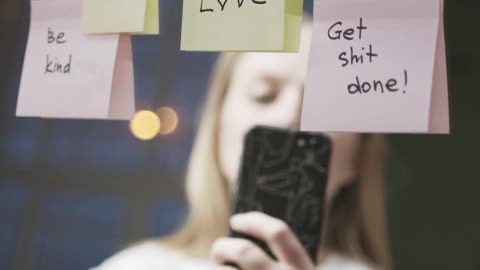 A Woman Taking Pictures Of Motivational Words Written On Stick Papers Over A Mirror