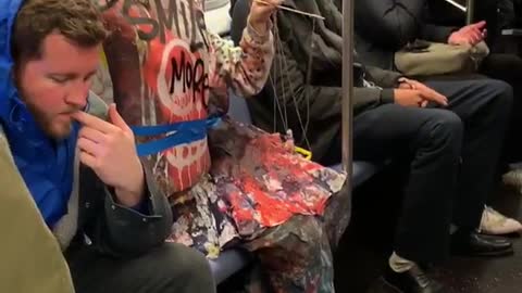 "smile more" mannequin puppet sitting on subway train
