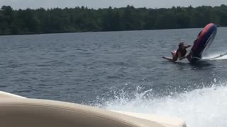 Girl flies off water tube behind boat