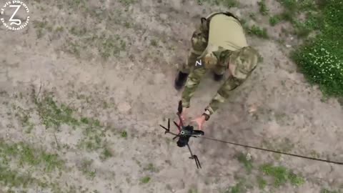 🇷🇺🇺🇦 Evacuation of a Russian fallen drone from the battlefield with the help of another drone.