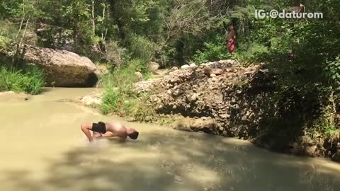 Shirtless man black shorts hits back in river