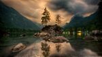 NATURE(green trees on brown rock formation on lake during daytime)