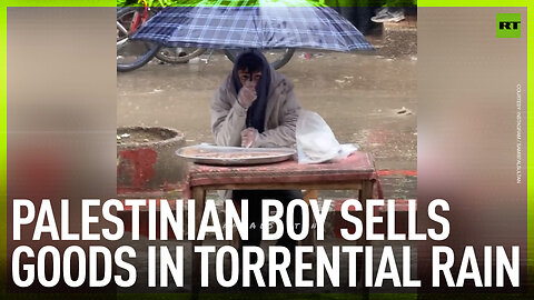 Palestinian boy sells goods in torrential rain