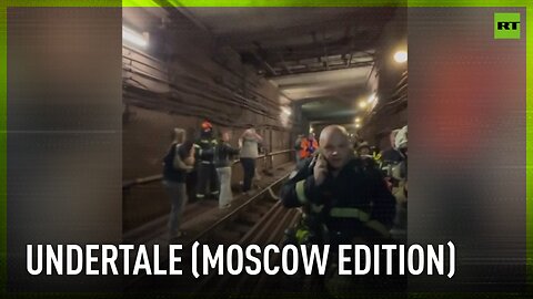 Passengers walk trough Moscow metro tunnel