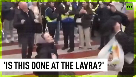 Dancing activists mock praying woman outside monastery