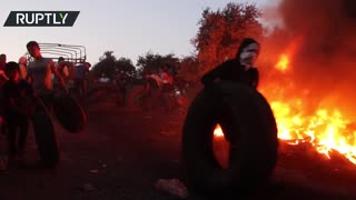 Palestinian protesters carry torches and set tires alight in a rally