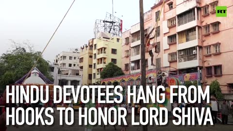 Hindu devotees hang from hooks to honor Lord Shiva