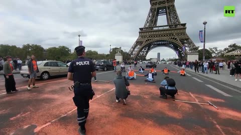 Climate activists cover Paris bridge with orange paint, hamper traffic