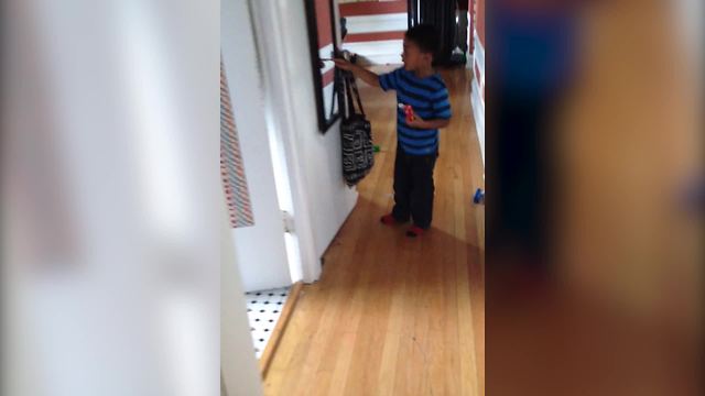A Tot Boy Talks To His Reflection In A Mirror
